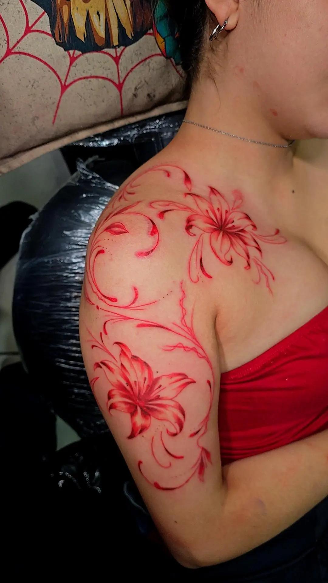 Tatuaje floral rojo en hombro